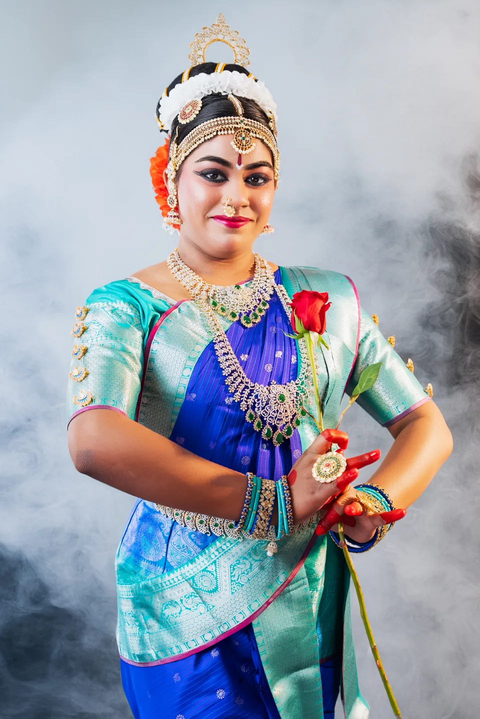 Classical dancer in blue and turquoise in a portrait against a pale smoky background