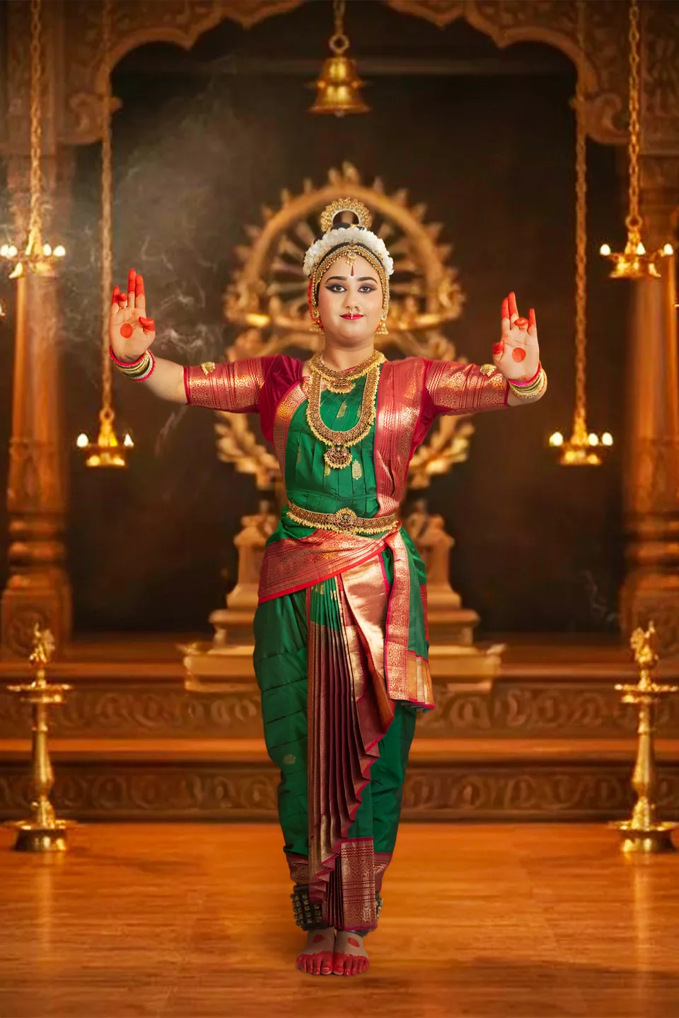 Classical dancer in green and red standing in an ornate golden setting
