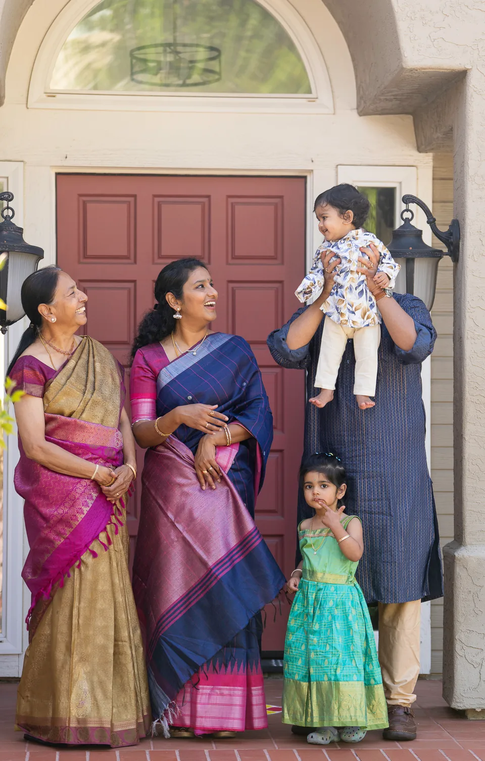 Family smiling together on the steps outside a home