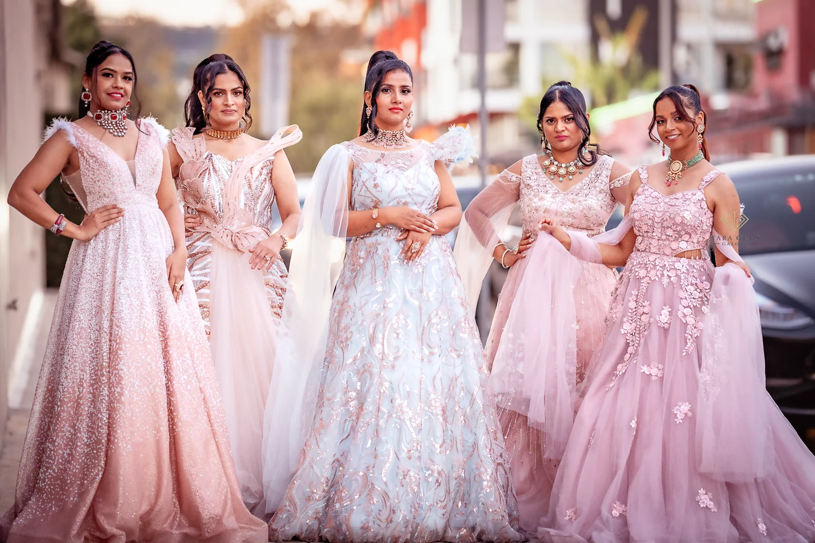 Bride and four women in pastel pink wedding attire standing together outdoors