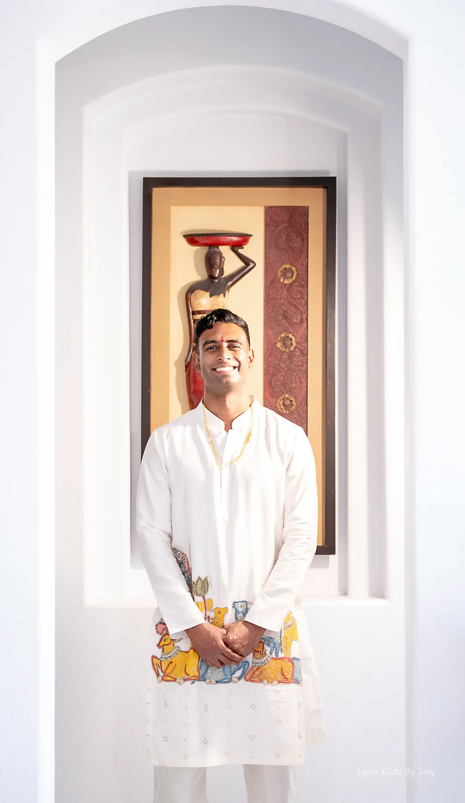 Man in a white traditional outfit standing in a doorway