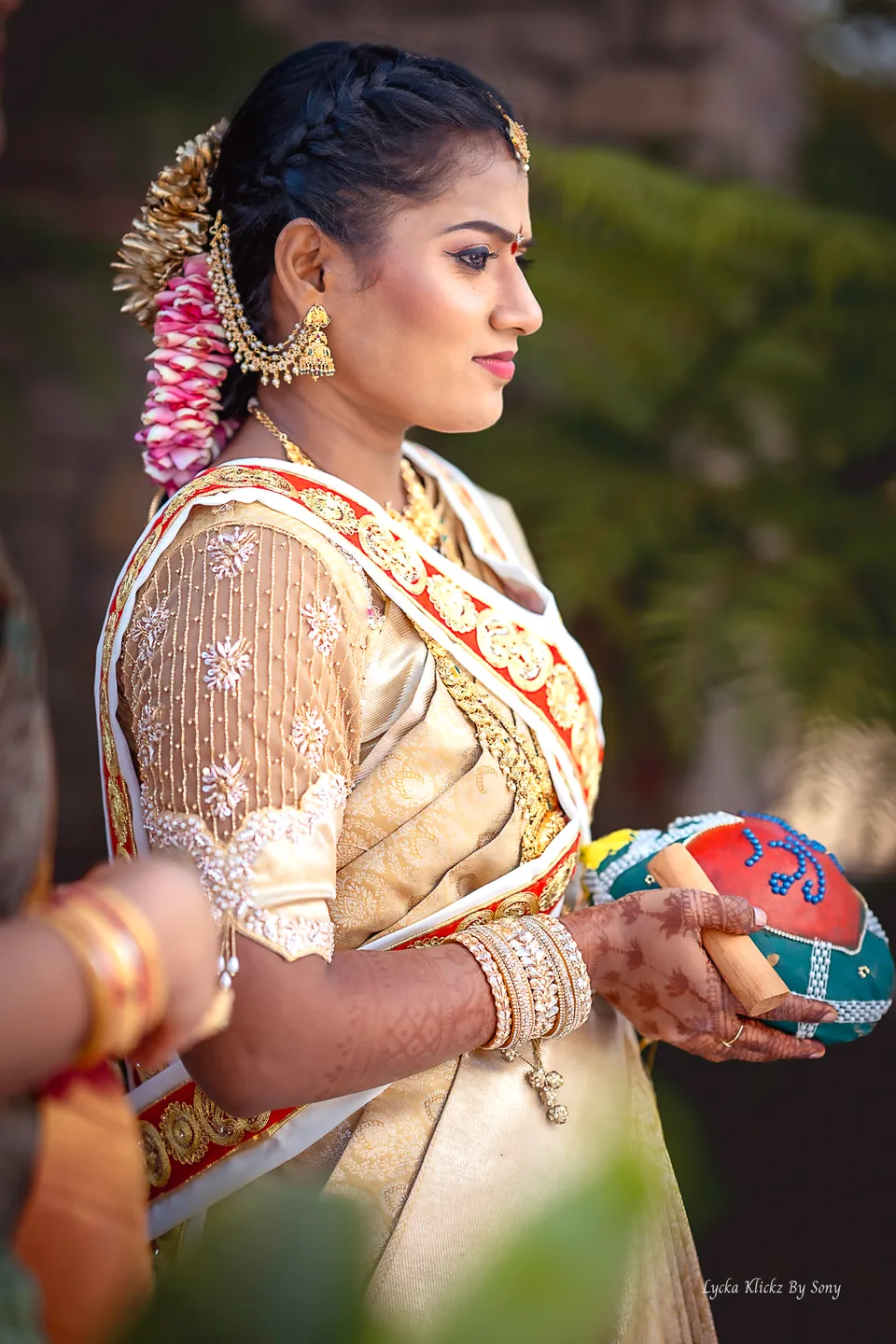 Bride in a pale gold sari with flowers in her hair